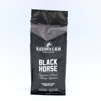 Black coffee bag labeled 'Blacksmith & Bean' on a light gray background