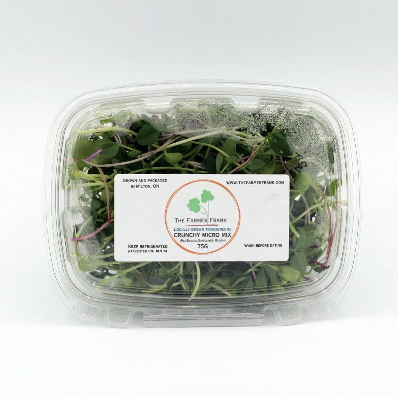 Container of microgreens with a label on a white background