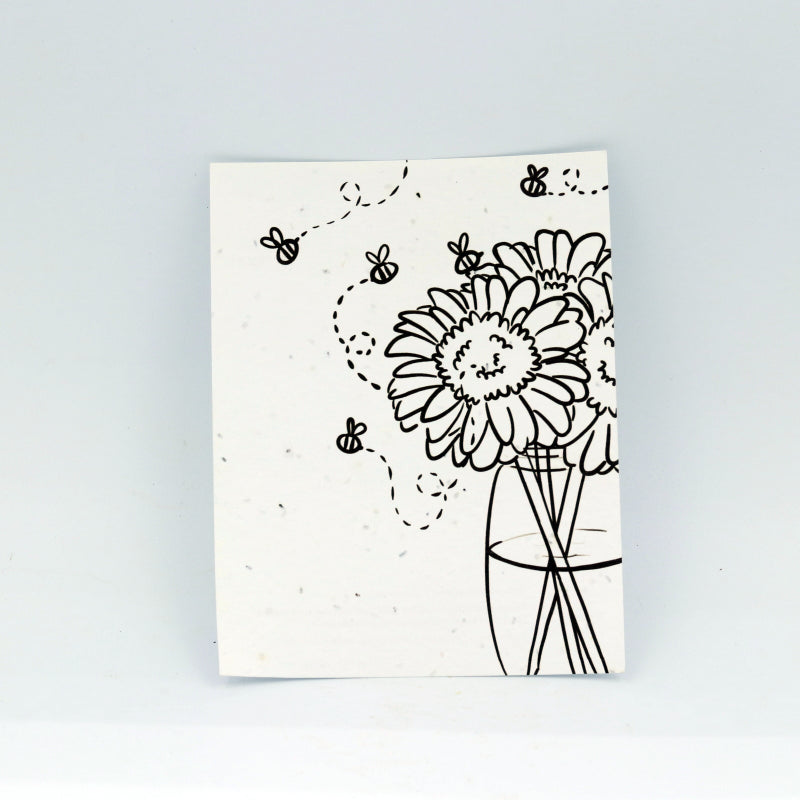 Notebook with black line art of flowers and bees on a white background